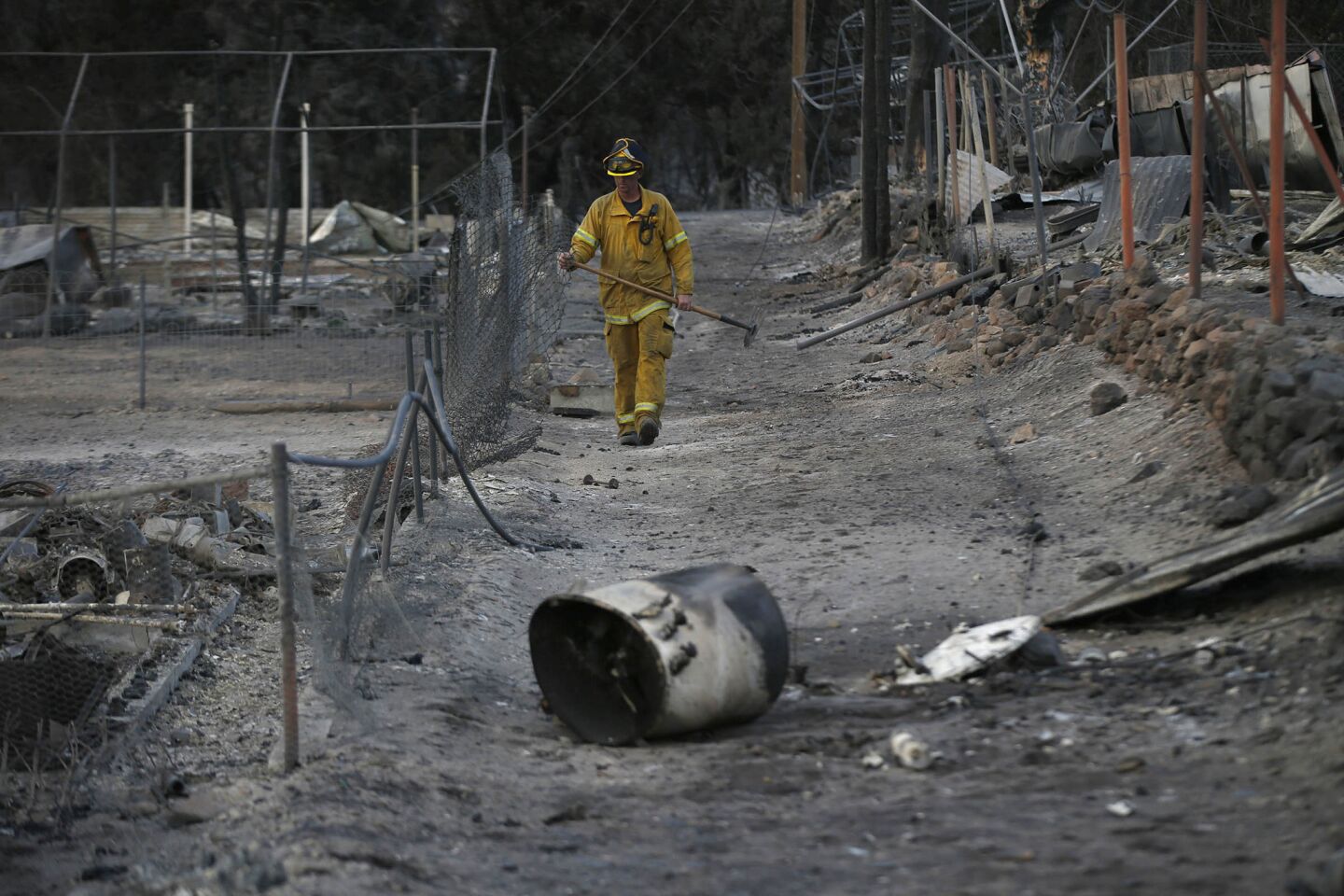 Vacaville firefighter Chris Mickelson looks for hot spots where dozens of homes lay in ruins a day after a wildfire, pushed by heavy winds, struck Weed, Caliif.