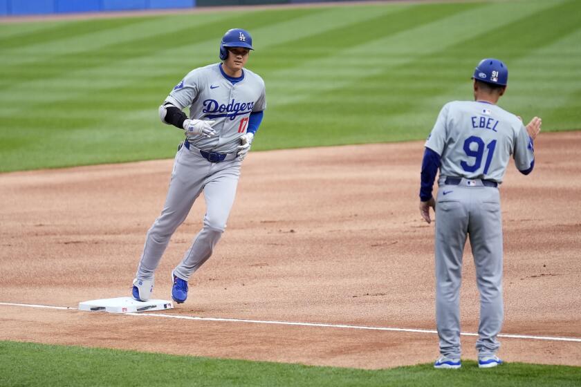Los Angeles Dodgers' Shohei Ohtani, left, rounds third towards third base coach Dino Ebel on a home run off Chicago White Sox starting pitcher Chris Flexen during the first inning of a baseball game Tuesday, June 25, 2024, in Chicago. (AP Photo/Charles Rex Arbogast)