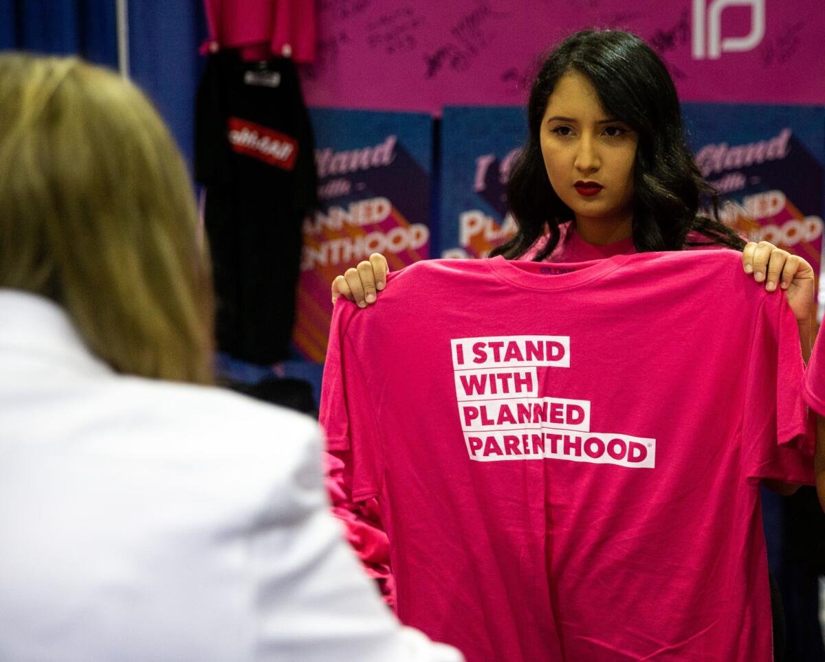 A volunteer holds up a shirt at the Planned Parenthood party.