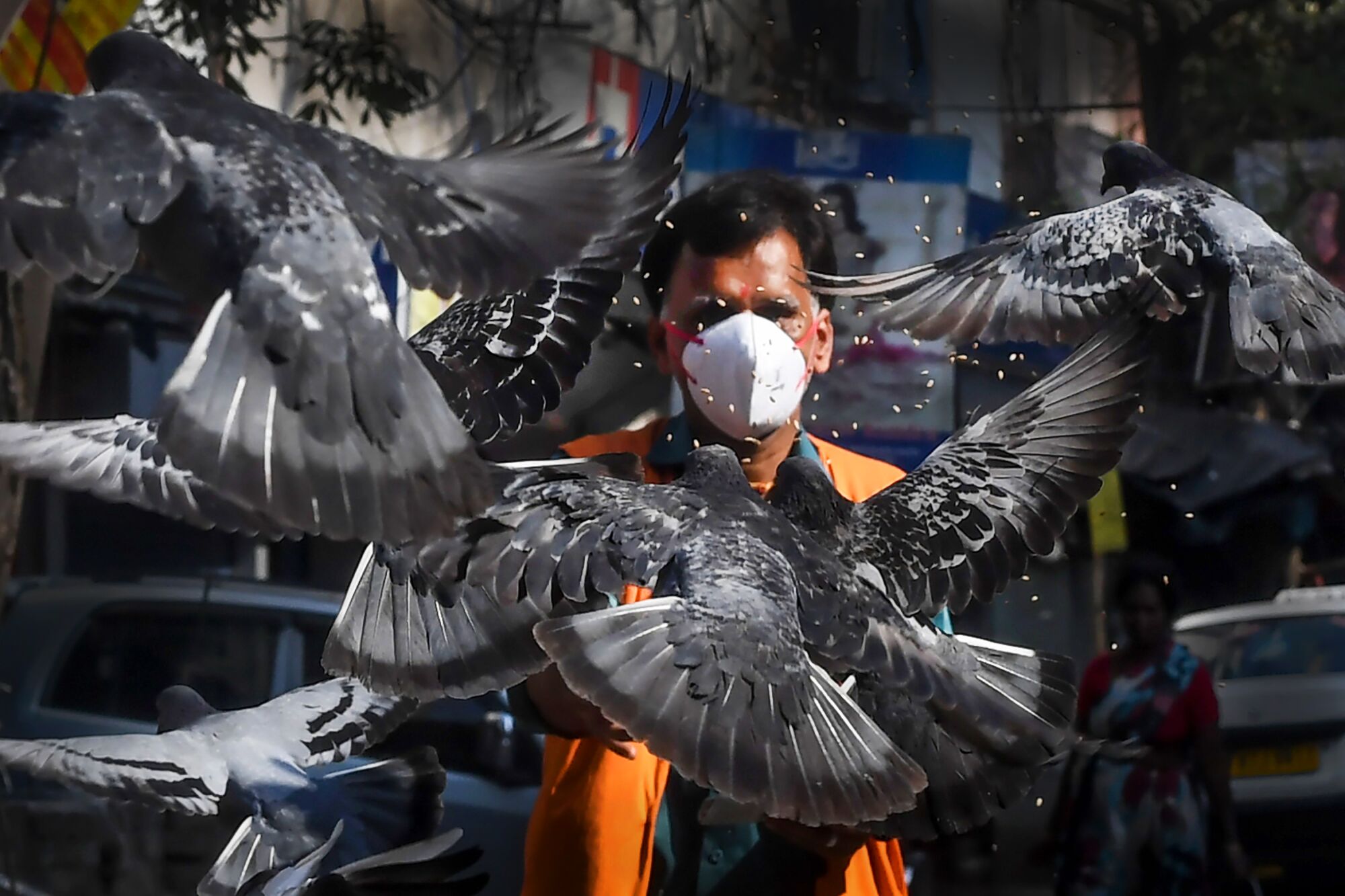 INDIA: A man wearing a facemask feeds pigeons on a empty street during a 21-day government-imposed nationwide lockdown as a preventive measure against the COVID-19 coronavirus in Kolkata on March 26, 2020.