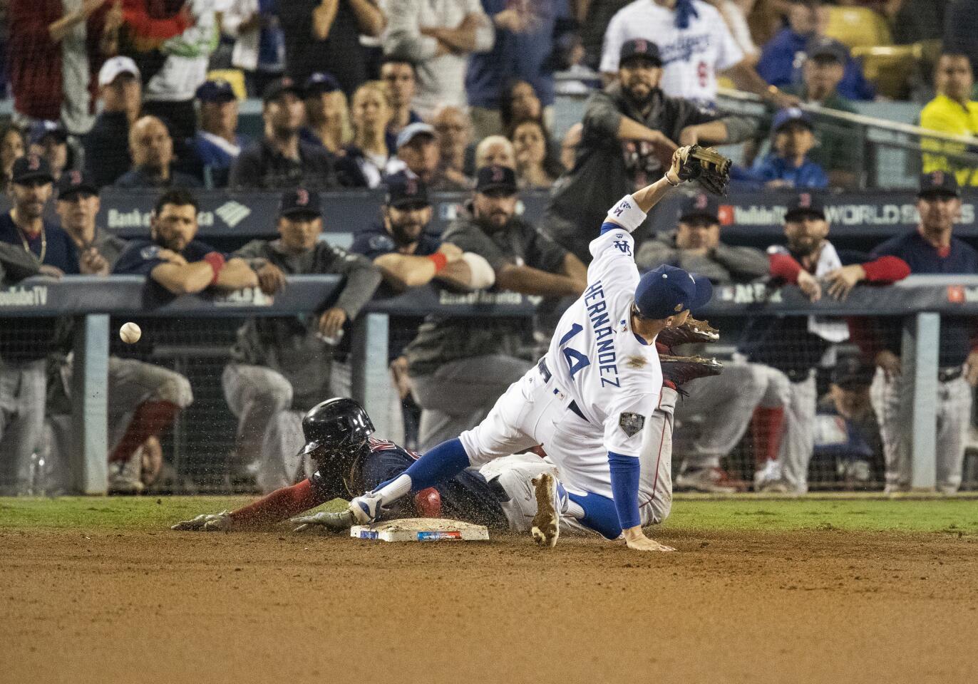 Red Sox third baseman Eduardo Nunez slides safely into first base as Dodgers second baseman Enrique Hernandez can't handle the throw from relief pitcher Scott Alexander allowing the go-ahead run to score in the 13th inning.