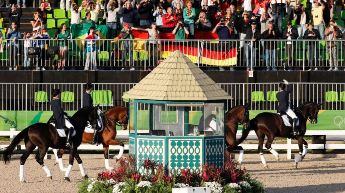 Germany's grand prix special dressage team takes a victory lap in front of the fans.
