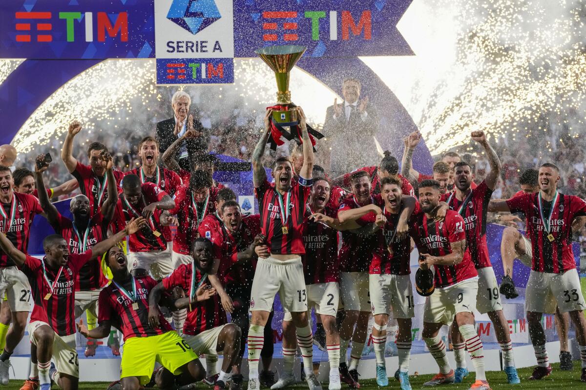 AC Milan players hold the trophy as they celebrate after winning the Italian Serie A title at the end of a match against Sassuolo, at the Citta del Tricolore stadium, in Reggio Emilia, Italy, Sunday, May 22, 2022. (AP Photo/Antonio Calanni)