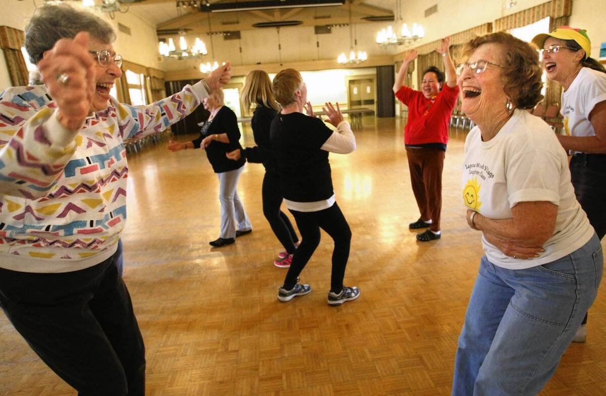 Rietta Oppenheim, left, 86, and Trudy Saltzman, 75, excel at the Laughter Yoga class in Laguna Woods.