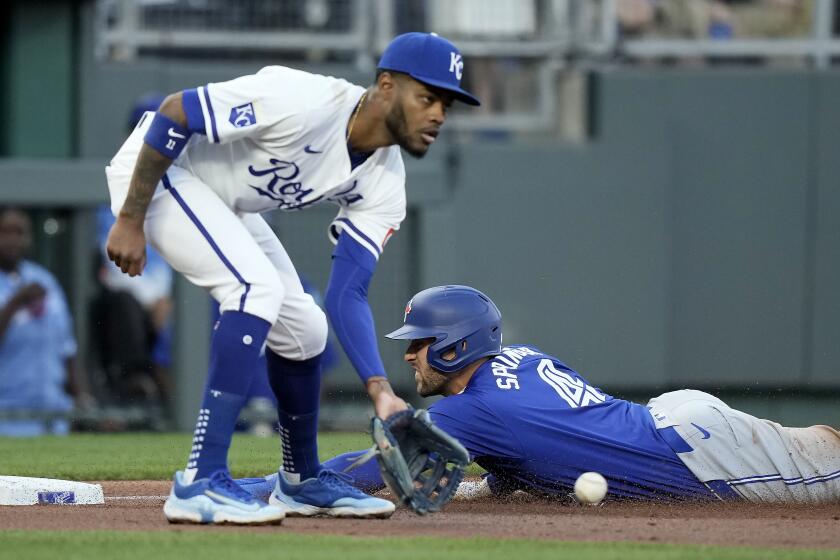 Toronto Blue Jays' George Springer (4) beats the tag by Kansas City Royals third baseman Maikel Garcia to advance to third on a single by Bo Bichette during the third inning of a baseball game Tuesday, April 23, 2024, in Kansas City, Mo. (AP Photo/Charlie Riedel)