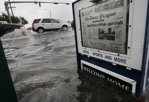 A Times-Picayune newspaper box reads "Welcome Home" as the water line just reaches it in New Orleans.