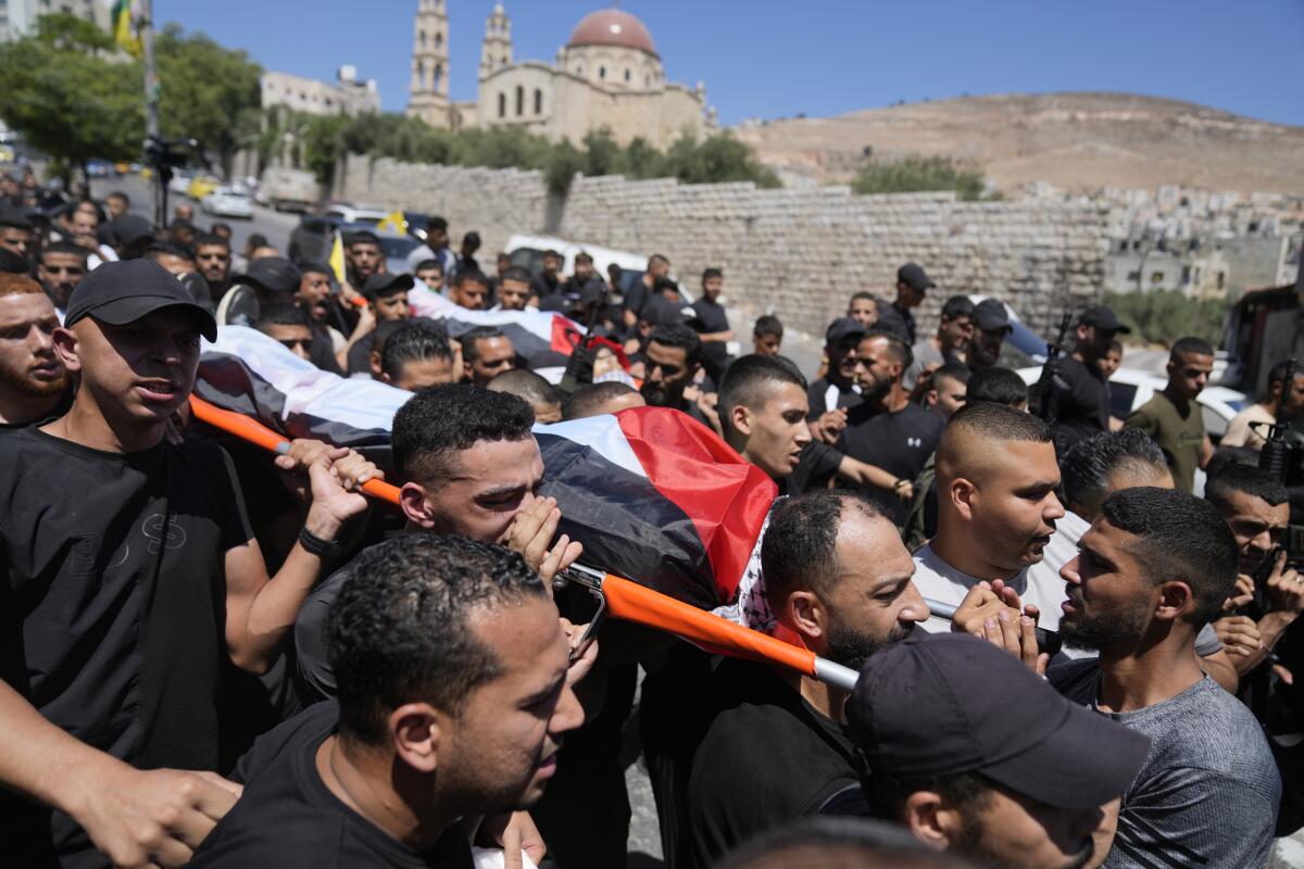 Mourners carrying the bodies of two young Palestinians