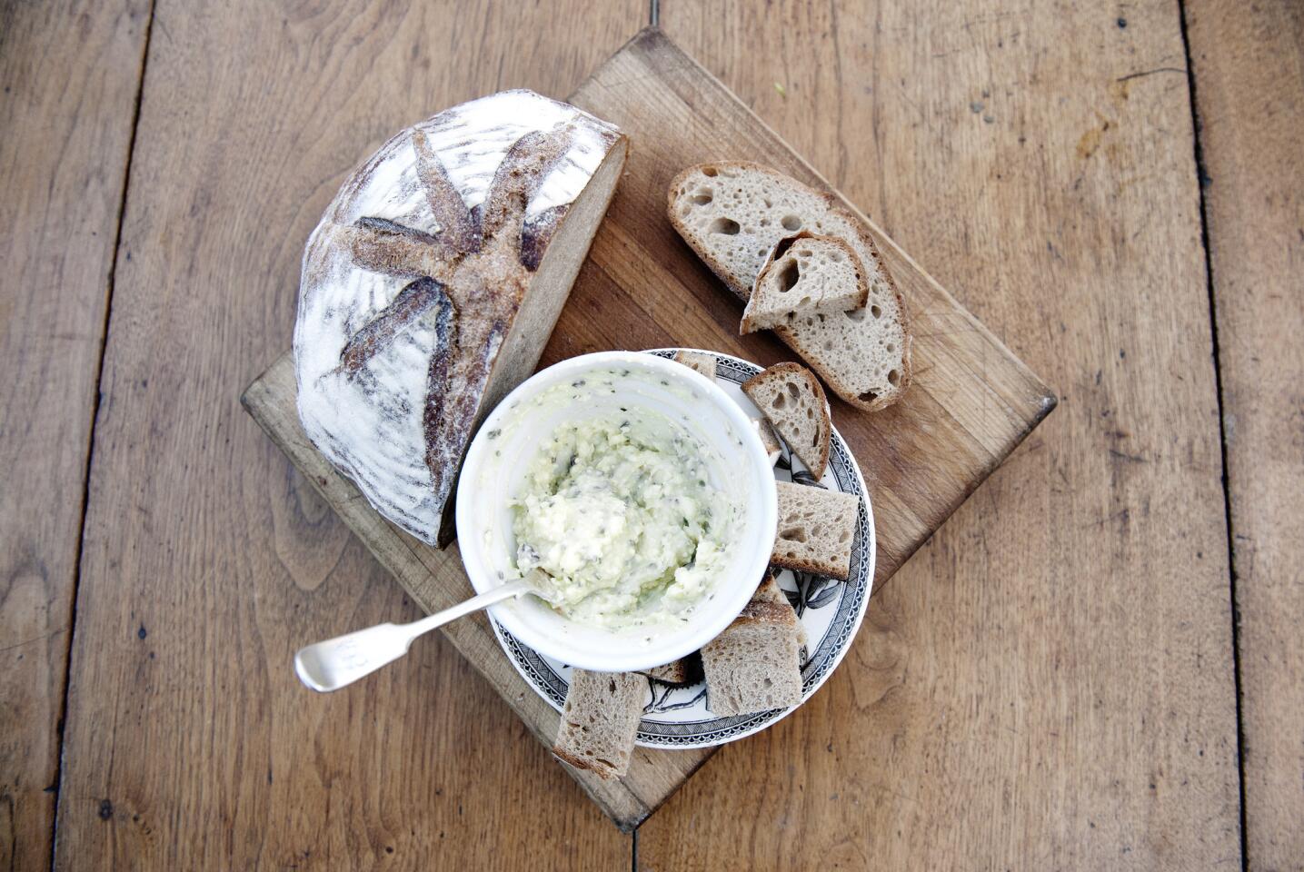 Homemade sourdough bread and a goat cheese spread made with smoked vegetables.