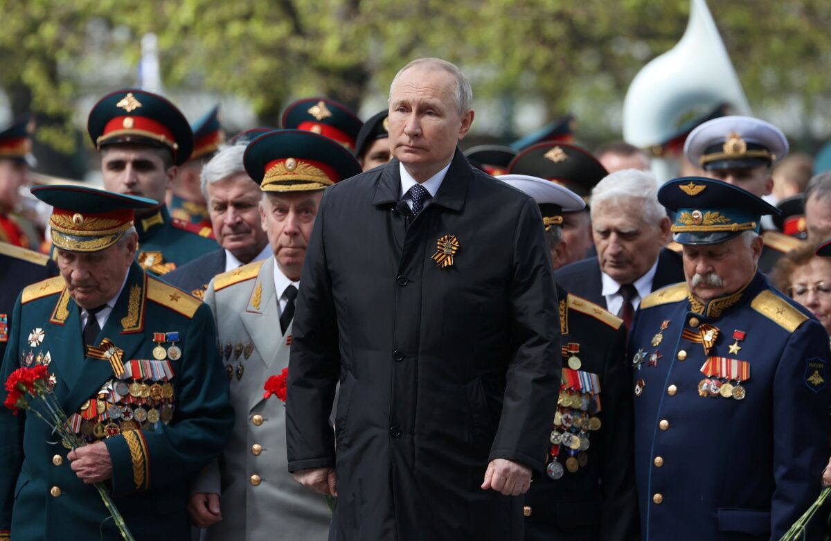 Russian President Vladimir Putin stands among military leaders,