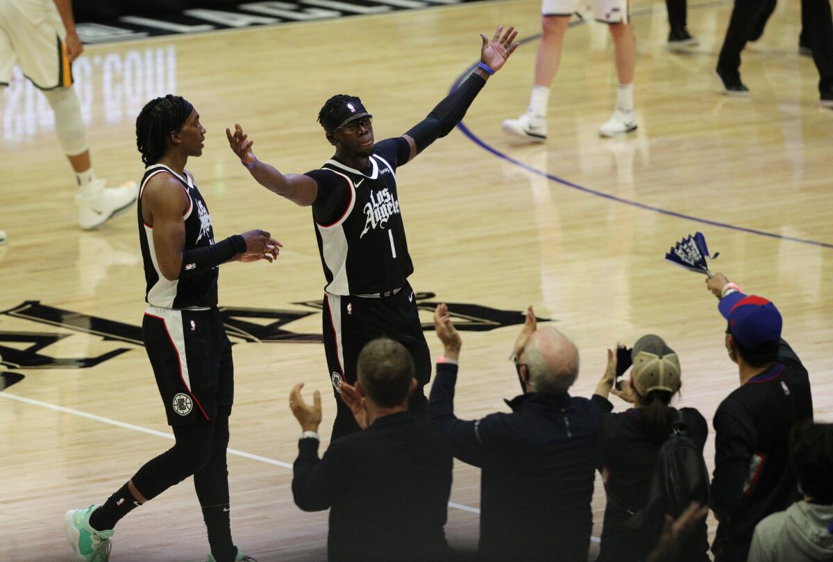 Reggie Jackson, right, and Terance Mann celebrate with the Staples Center crowd during a win over Utah on June 18, 2021.