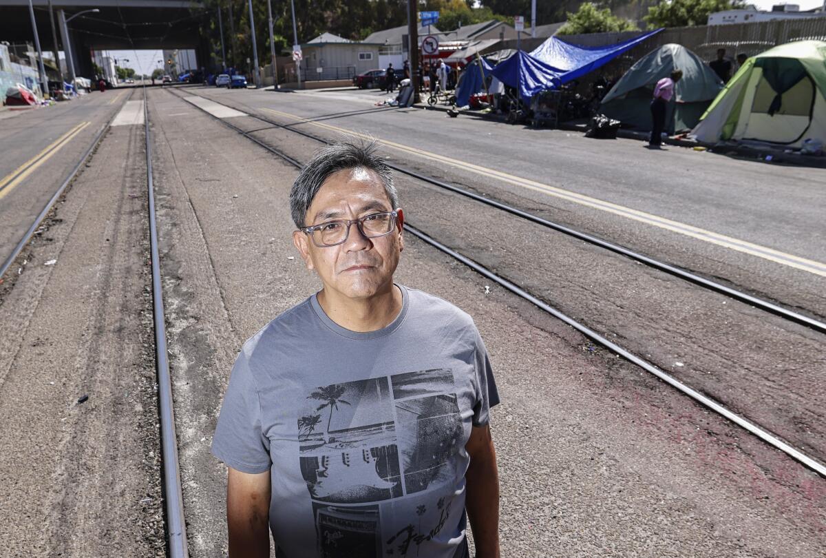 Author Frank Kensaku Saragosa, who was formerly homeless, stands near the intersection at 17th Street and Commercial Street.