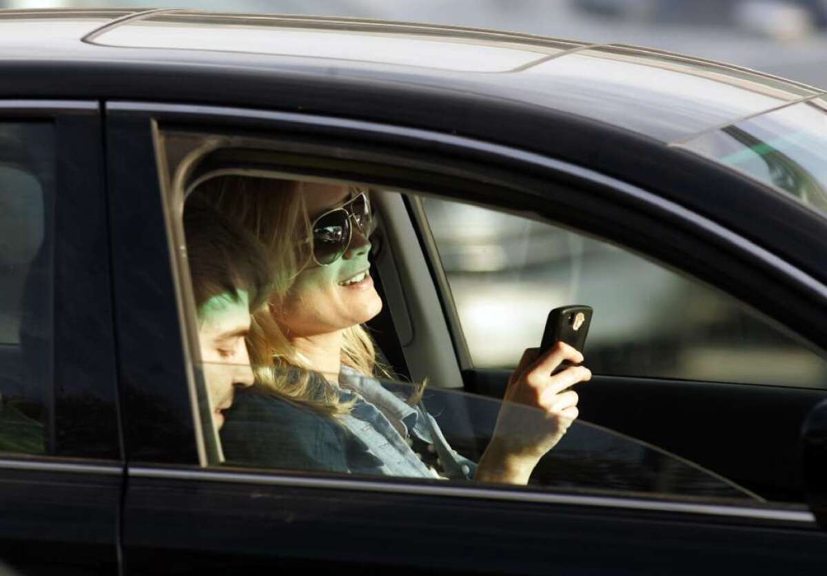 This driver is using her cellphone while trying to focus on the road ahead. A new study quantifies the risk of this and other types of distracted driving.