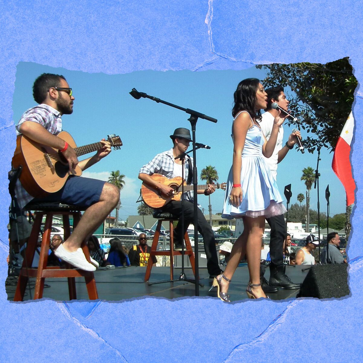 A young man and woman sing in front of two men sitting on stools and playing guitars on an outdoor stage.