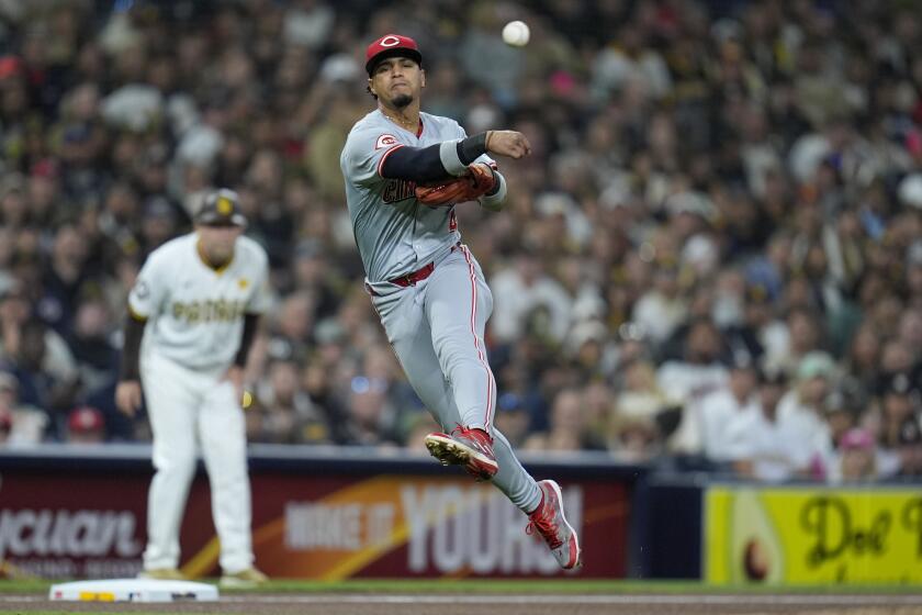 El tercera base de los Rojos de Cincinnati, Santiago Espinal, lanza a primera para retirar a Manny Machado, de los Padres de San Diego, durante la séptima entrada del juego de béisbol, el lunes 29 de abril de 2024, en San Diego. (AP Foto/Gregory Bull)