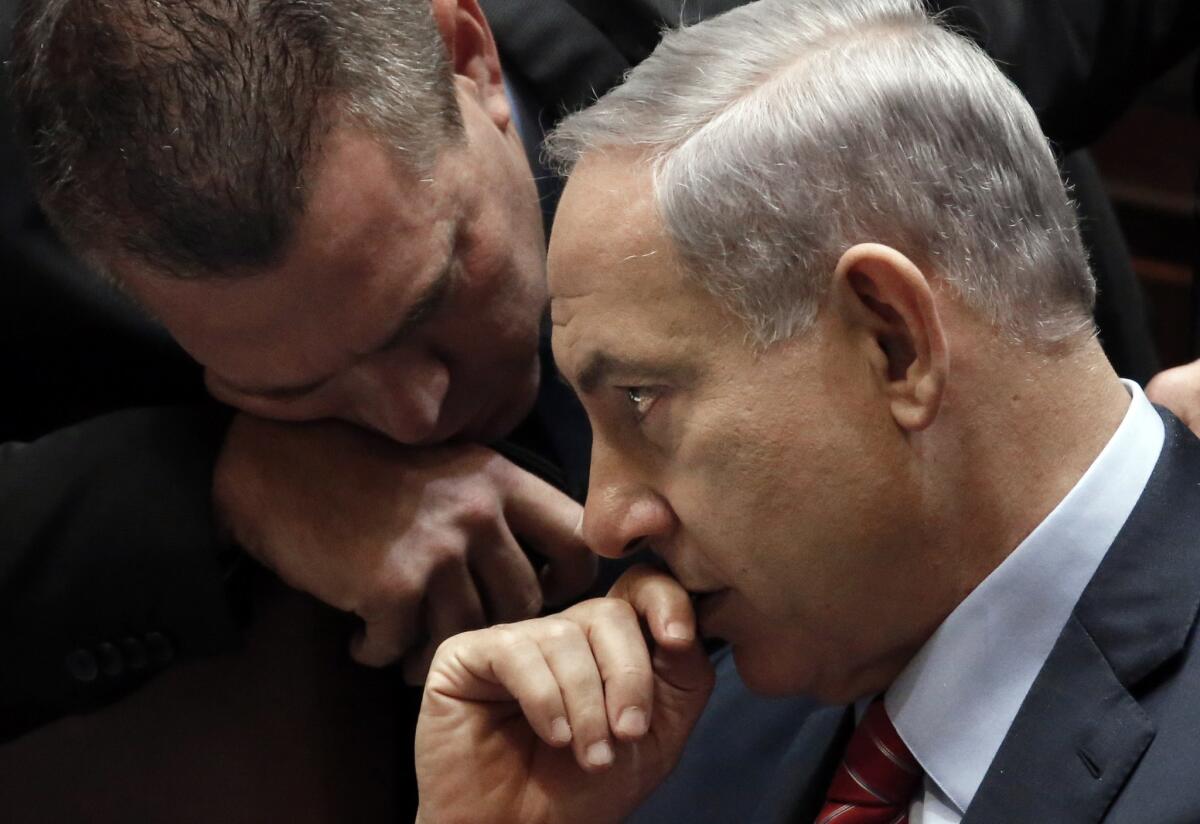 Israeli Prime Minister Benjamin Netanyahu, right, listens to an advisor during a vote Dec. 3 to dissolve the Knesset.