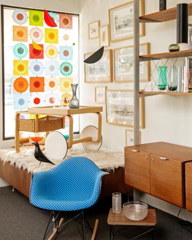 Midcentury furnishings and accessories including a blue molded chair and a wood bar cart