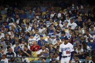LOS ANGELES, CA - AUGUST 19, 2021: Very few fans are wearing masks in the stands during as the Dodgers play the New York Mets at Dodger Stadium on August 19, 2021 in Los Angeles, California. On Friday, a mask mandate will be in place for all outdoor venues holding 10,000 people or more.(Gina Ferazzi / Los Angeles Times)