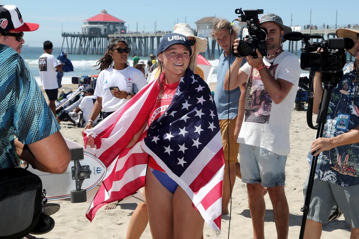 Team USA surfer Kirra Pinkerton is surrounded by members of the media after winning the ISA World Surfing Games on Saturday.