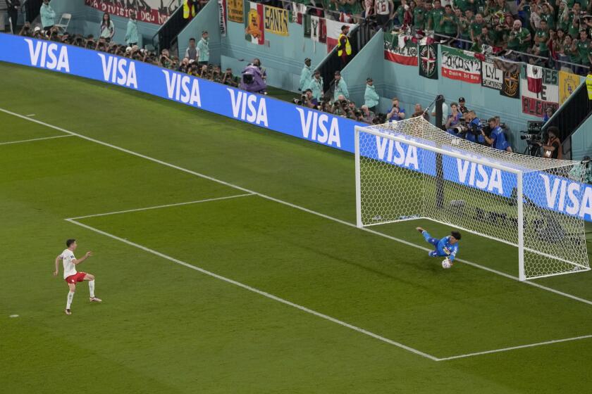 Mexico's goalkeeper Guillermo Ochoa saves on a penalty kick by Poland's Robert Lewandowski during the World Cup group C soccer match between Mexico and Poland, at the Stadium 974 in Doha, Qatar, Tuesday, Nov. 22, 2022. (AP Photo/Darko Vojinovic)