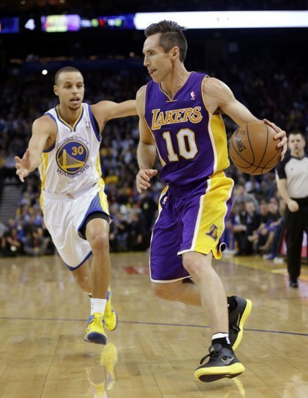 Steve Nash dribbles past the Golden State Warriors' Stephen Curry during a game in Oakland.