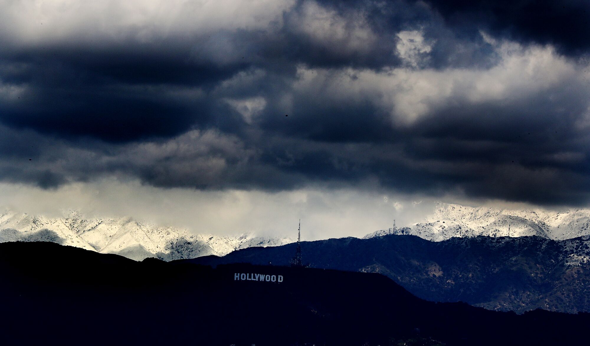 Storm clouds drift over the Hollywood sign and partially obscure mountains covered in snow on Feb. 26.