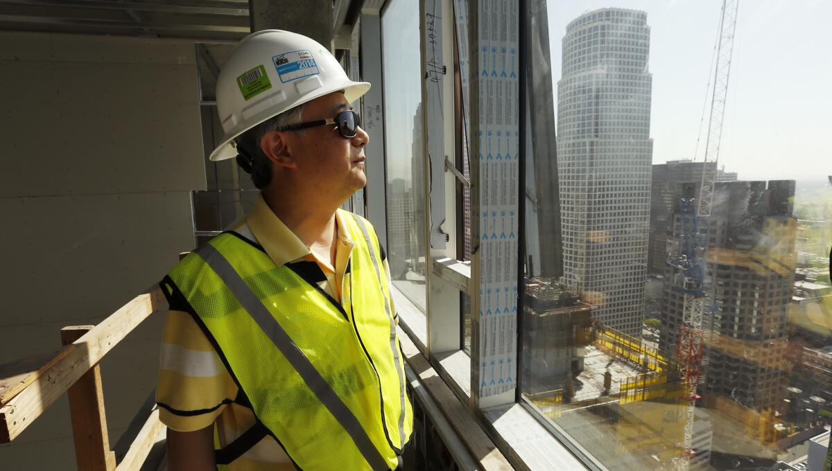 Winston Yan, CTO and vice president of Los Angeles Greenland USA, walks through nearly completed units in a collection of residential towers in downtown. The $1-billion mega-project is one of several by Chinese developers that are reshaping the downtown L.A. skyline.