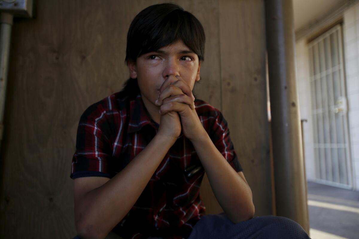 Eddie Martinez, 14, sits crying in the stairwell at the Country Inn motel in San Bernardino as his girlfriend Breanna’s mom jealously berates her for texting her dad.