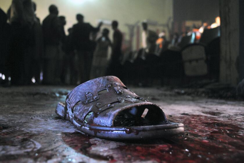A bloody shoe lies on the ground at the site of a grenade attack on a crowded movie theater in Peshawar, Pakistan.