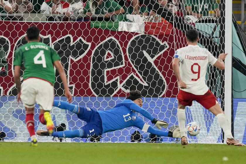 Mexico goalkeeper Memo Ochoa blocks a penalty kick by Poland's Robert Lewandowski 
