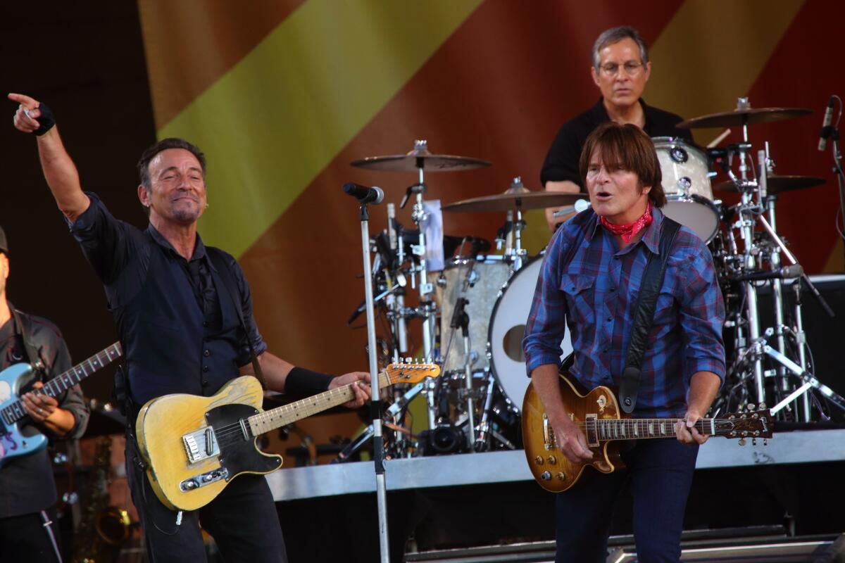 Bruce Springsteen, left, and the E Street Band with special guest John Fogerty, right, perform at the 2014 New Orleans Jazz & Heritage Festival at Fair Grounds Race Course.