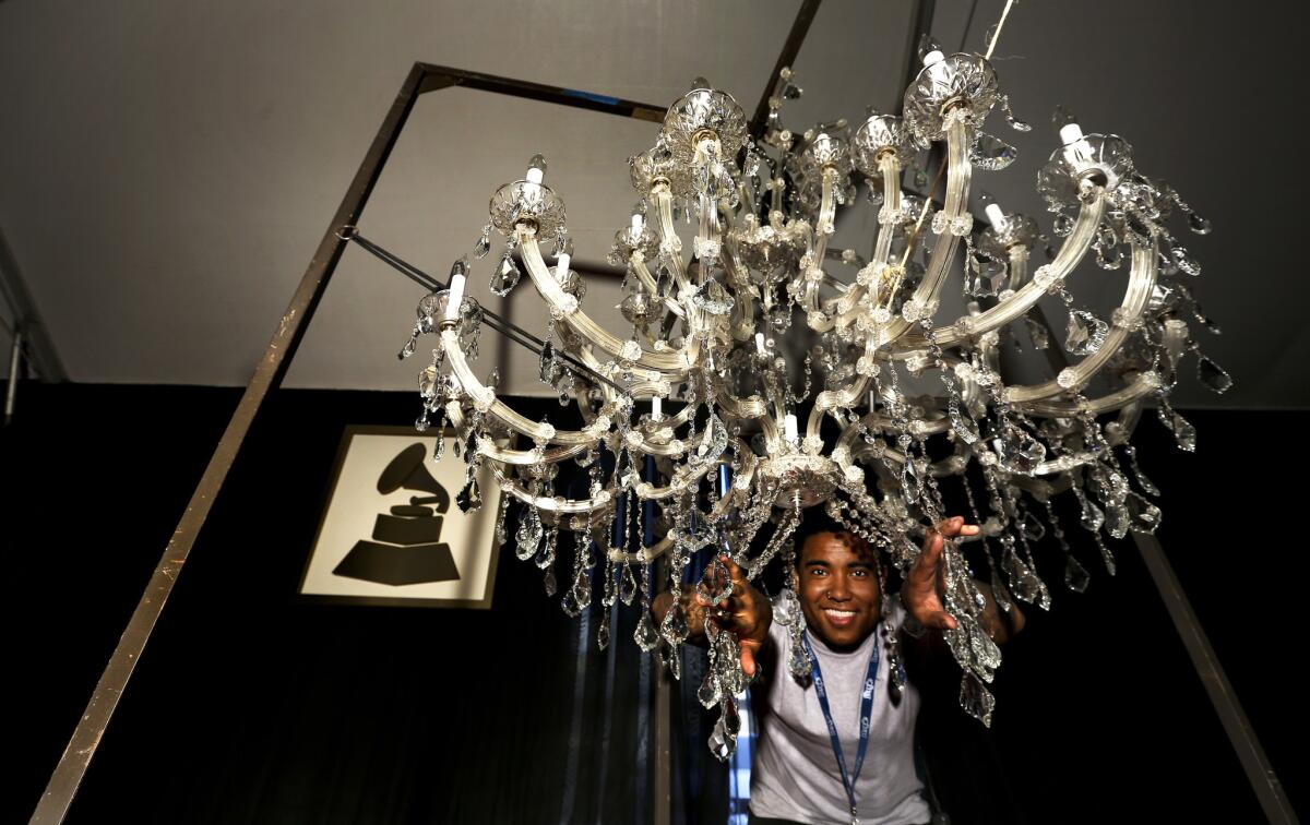 Spencer Knox, 28, production assistant for the red carpet area at the Grammy Awards, with one of 17 chandeliers that will go up above the 520-foot-long red carpet.