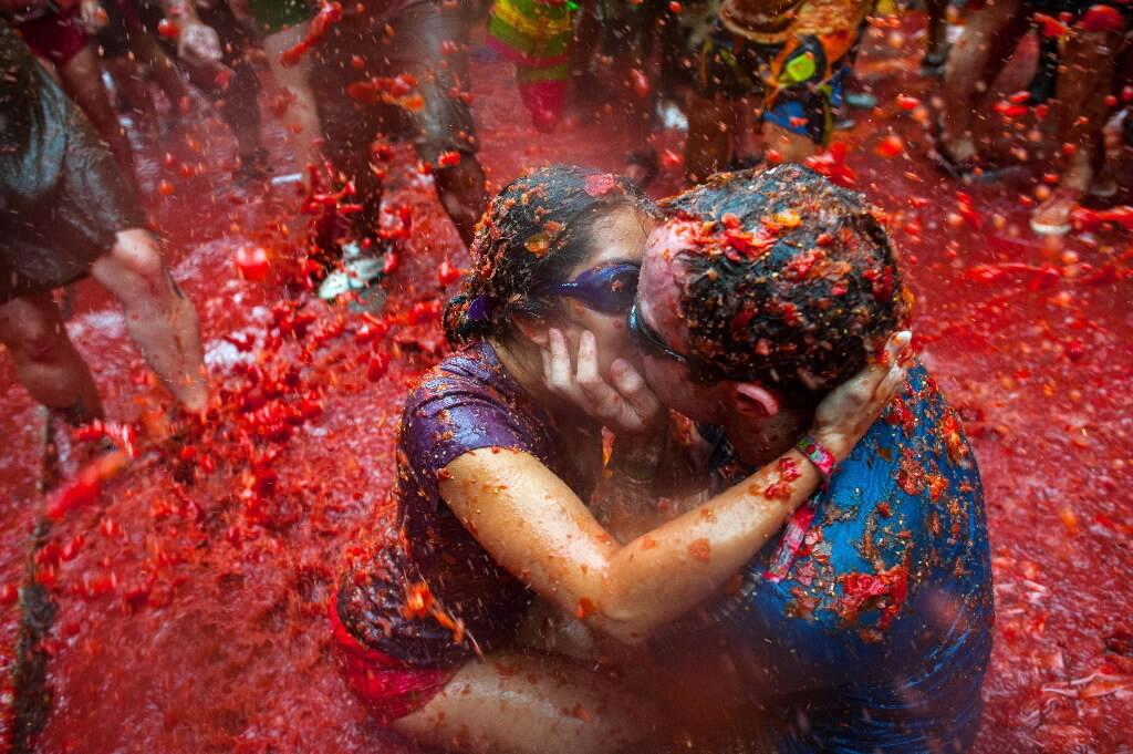 People take part in the annual "Tomatina" festivities in Bunol, near Valencia, on August 28, 2013. Twenty thousand people hurled 130 tons of squashed tomatoes at each other, drenching the streets in red in a gigantic Spanish food fight known as the Tomatina.