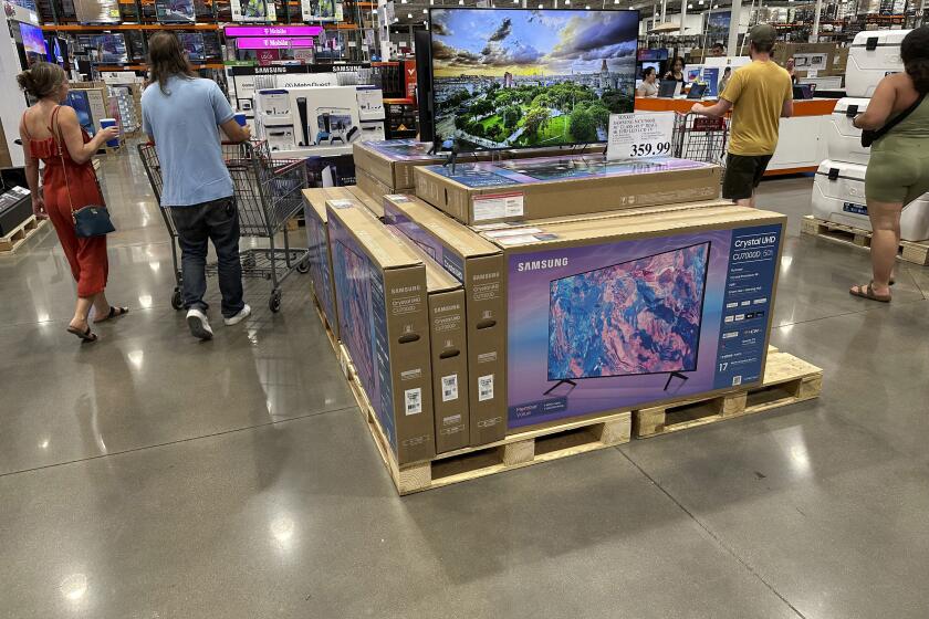 Shoppers glide past a display of big-screen televisions in a Costco warehouse on Tuesday, July 11, 2023, in Sheridan, Colo. On Tuesday, July 18, the Commerce Department releases U.S. retail sales data for June. (AP Photo/David Zalubowski)