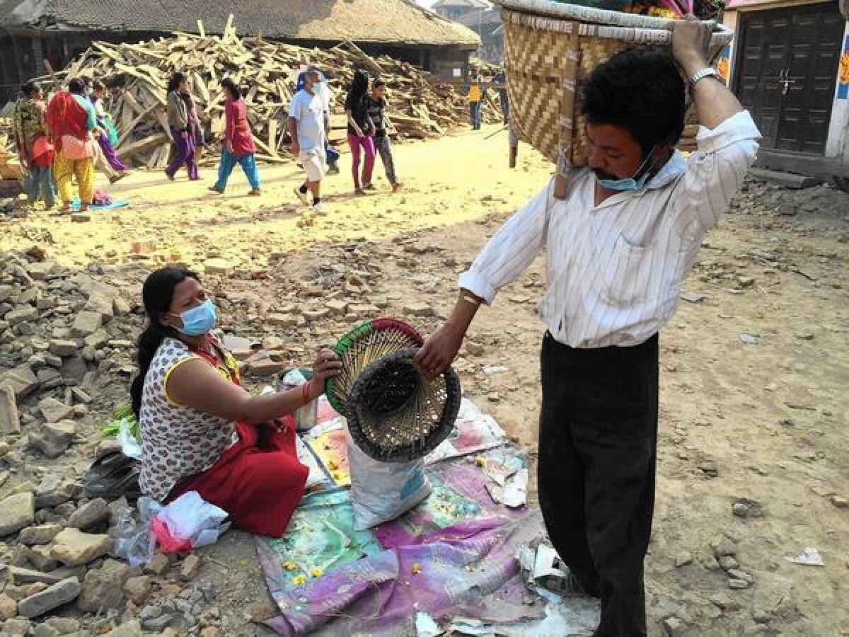 Ratna Bahadur Malatar and his wife, Mithai, work on assembling flower garlands in Katmandu's Durbar Square.