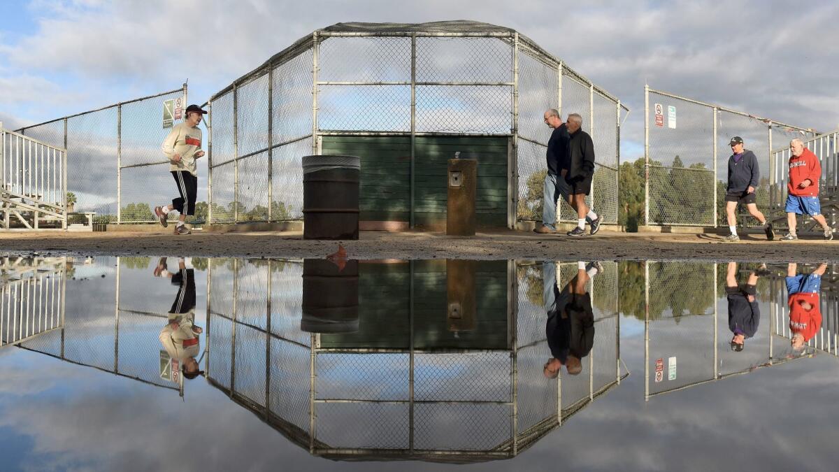 People exercise under clearing skies after the evening rain at the Van Nuys/Sherman Oaks Park.