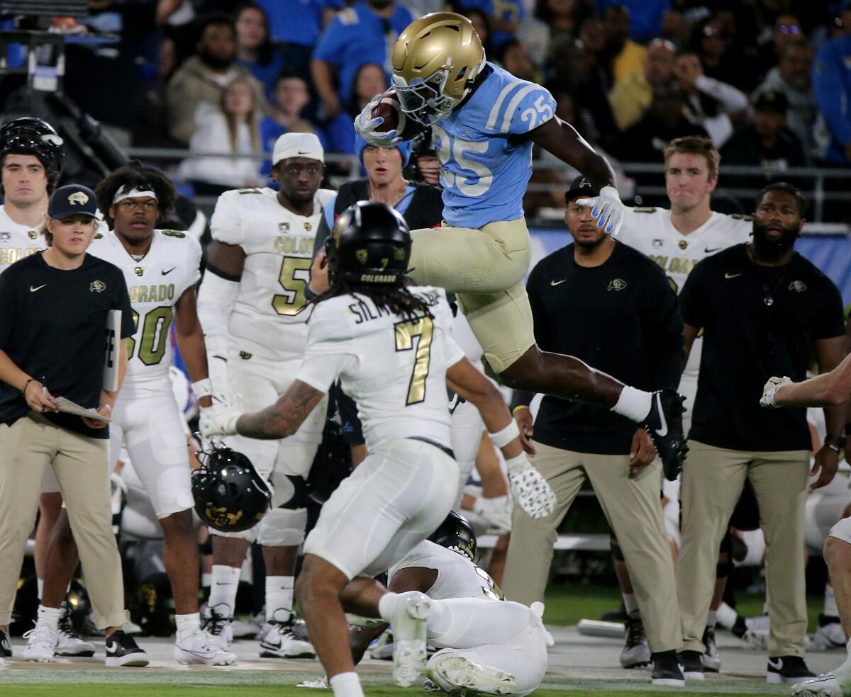 UCLA running back T.J. Harden hurdles over Colorado cornerback Omarion Cooper in the fourth quarter.