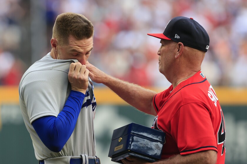 Freddie Freeman des Dodgers réagit avec émotion lorsqu'il se voit présenter sa bague des World Series par le manager des Braves, Brian Snitker.