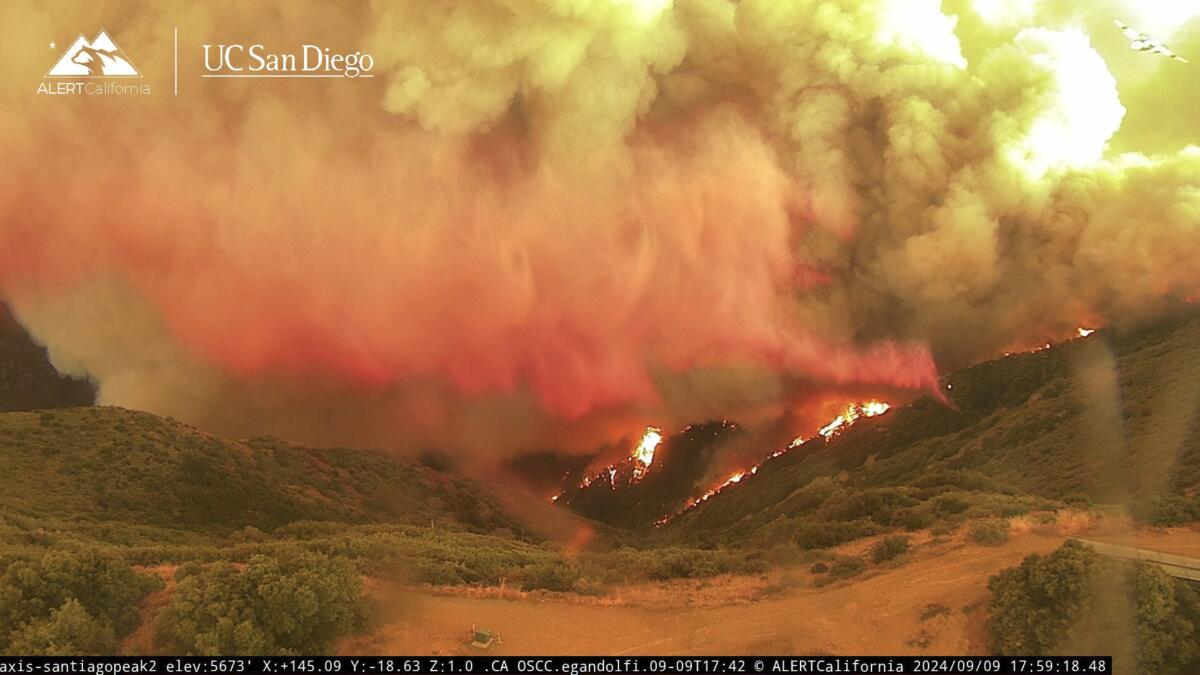 Smoke and flames rise along a ridge.