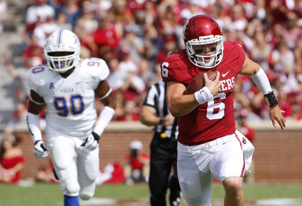 Oklahoma quarterback Baker Mayfield runs for a touchdown ahead of Tulsa defensive end Frankie Davis (90) during the first quarter of the Sooners' 52-38 win over the Hurricane.