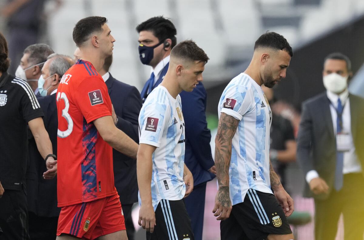 From right, Argentina's players Nicolas Otamendi, Giovani Lo Celso and goalkeeper Emiliano Martinez, walk off the field after the qualifying soccer match for the FIFA World Cup Qatar 2022 against Brazil was interrupted by health officials in Sao Paulo, Brazil, Sunday, Sept.5, 2021. (AP Photo/Andre Penner)
