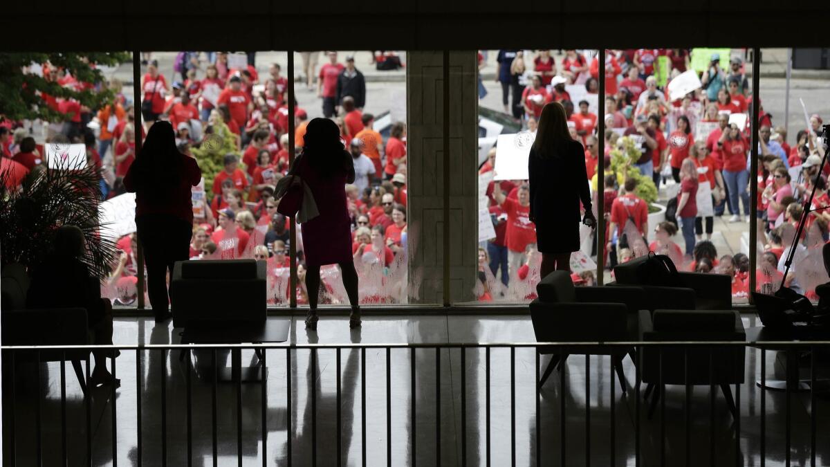 People watch from inside the Legislative Building as participants gather during a teachers rally at the General Assembly in Raleigh, N.C. on Wednesday.