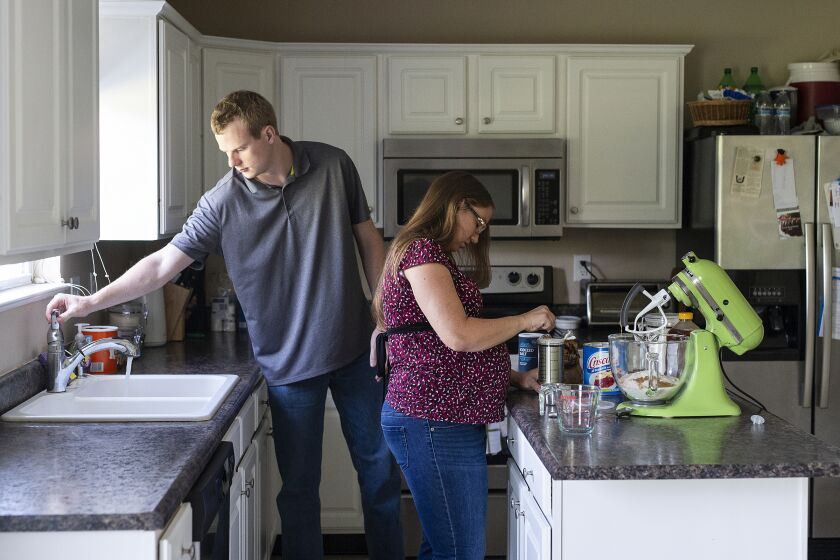 Rebecca Grimm makes homemade bread alongside her husband, Mark, at their home in Westfield, Ind., on Sunday August, 25, 2019. Grimm was pregnant with her second child in 2018 when she suffered a miscarriage but did not pass the fetus. She and husband were billed almost $6,000.