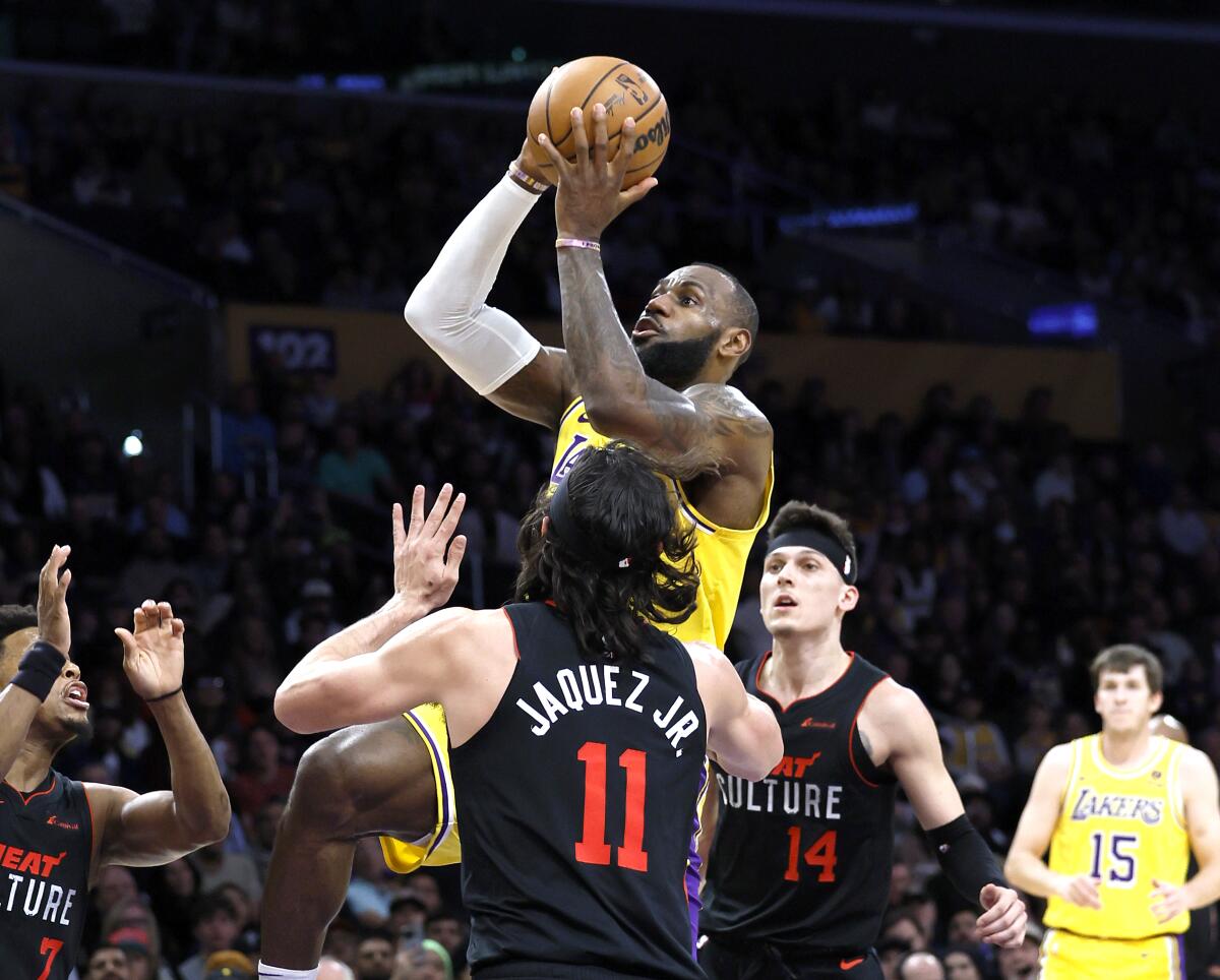 Lakers forward LeBron James drives to the hoop and takes a shot over Miami Heat guard Jaime Jaquez Jr. 