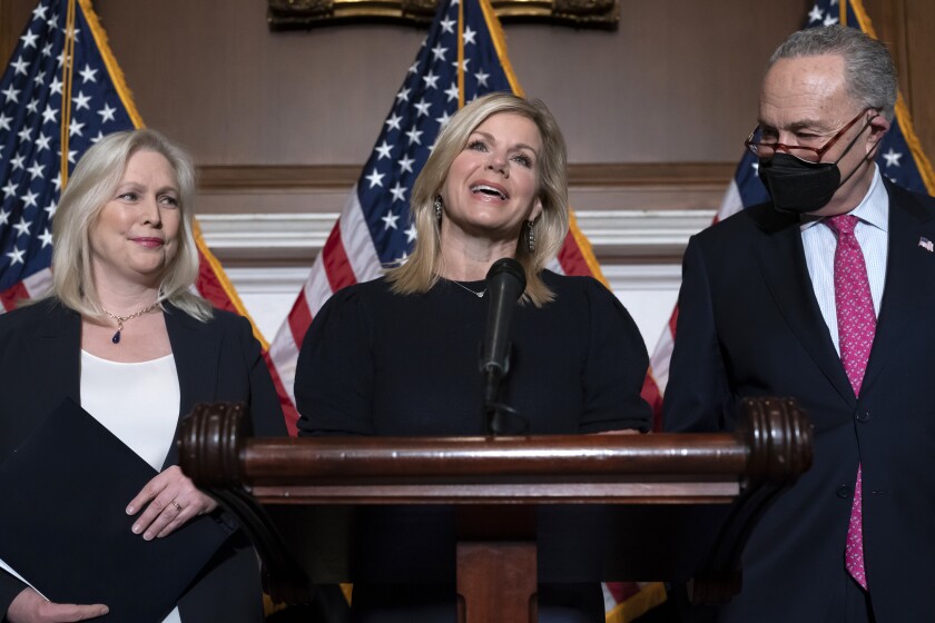 Former Fox News anchor Gretchen Carlson, center, celebrates with Sen. Kirsten Gillibrand, D-N.Y., left, and Senate Majority Leader Chuck Schumer, D-N.Y., after Congress gave final approval to legislation guaranteeing that people who experience sexual harassment at work can seek recourse in the courts, during a news conference at the Capitol in Washington, Thursday, Feb. 10, 2022. Since her 2016 sexual harassment lawsuit against then Fox News Chairman and CEO Roger Ailes, Carlson has worked to ban non-disclosure agreements and forced arbitration clauses in employment agreements to prevent victims of sexual harassment from being silenced. (AP Photo/J. Scott Applewhite)