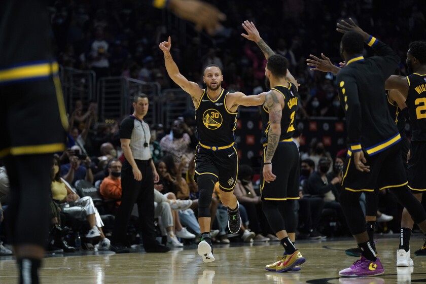 El base de los Warriors de Golden State Stephen Curry celebra tras encestar un triple en el encuentro ante los Clippers de Los Ángeles el domingo 28 de noviembre del 2021. (AP Foto/Ashley Landis)