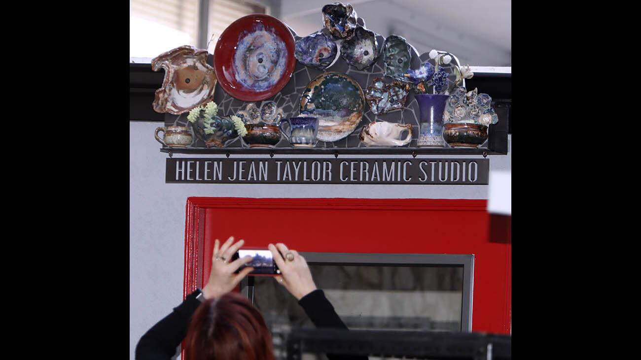 A person takes a photo of the new sign on top of the ceramic studio door after dedication of the Helen Jean Taylor Ceramics Studio, at the Community Center of La Cañada Flintridge, on Saturday, Nov. 4, 2017.
