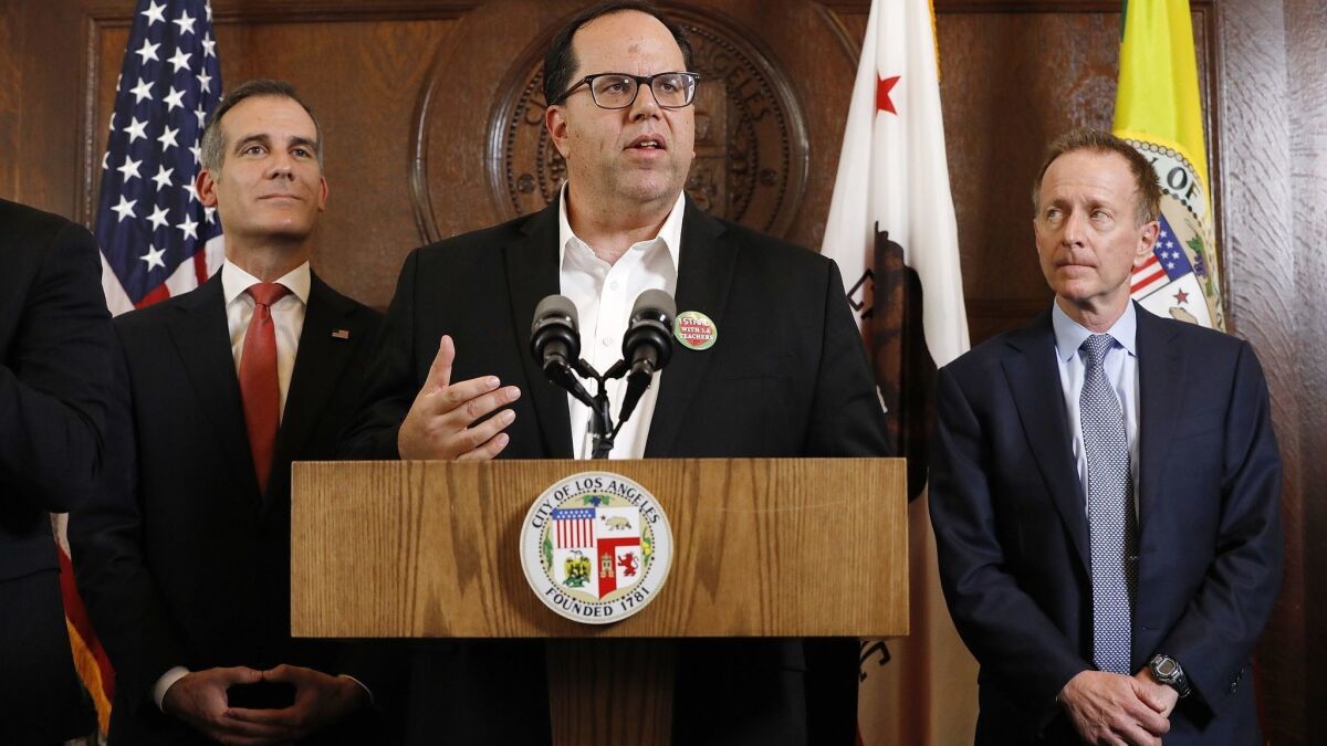 United Teachers Los Angeles President Alex Caputo-Pearl is flanked by L.A. Mayor Eric Garcetti, left, and LAUSD Supt. Austin Beutner while speaking about a resolution to the teachers' strike Tuesday.