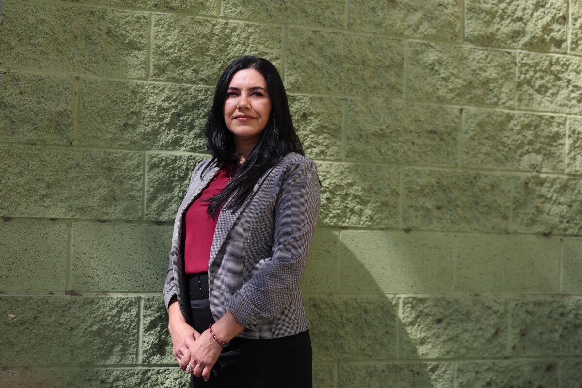 L.A. Unified counselor Belinda Barragan poses for a portrait in front of a brick wall.