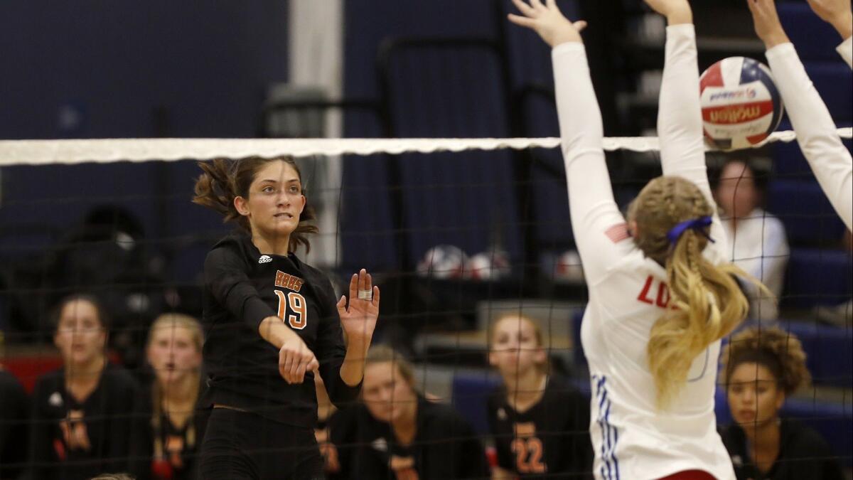 Sabrina Phinizy (19) scores for Huntington Beach High during the second set of a Surf League match at Los Alamitos on Wednesday.
