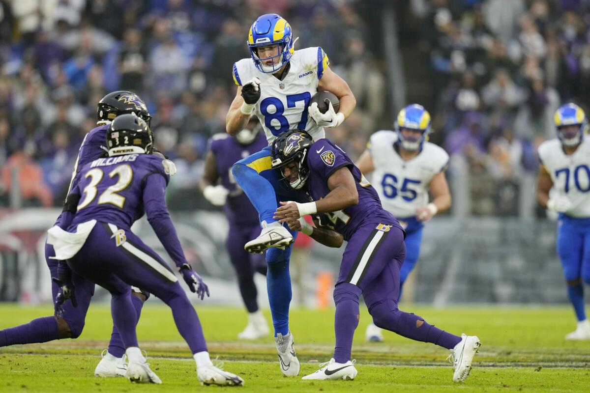 Rams tight end Davis Allen (87) tries to leaps through the Ravens defense after making a catch.
